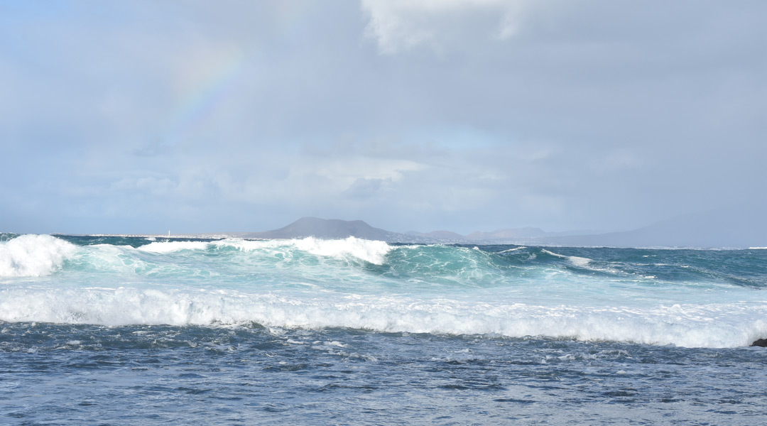 Das stürmische Meer mit einem kleinen Regenbogen