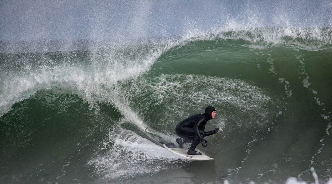 kaltwassersurfen in europa - surferin in großer welle