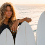 Surfboard-Volumen verstehen: So findest du das richtige Board surfergirl mit 3 boards vor sich um das volumen von surfbrettern zu verdeutlichen